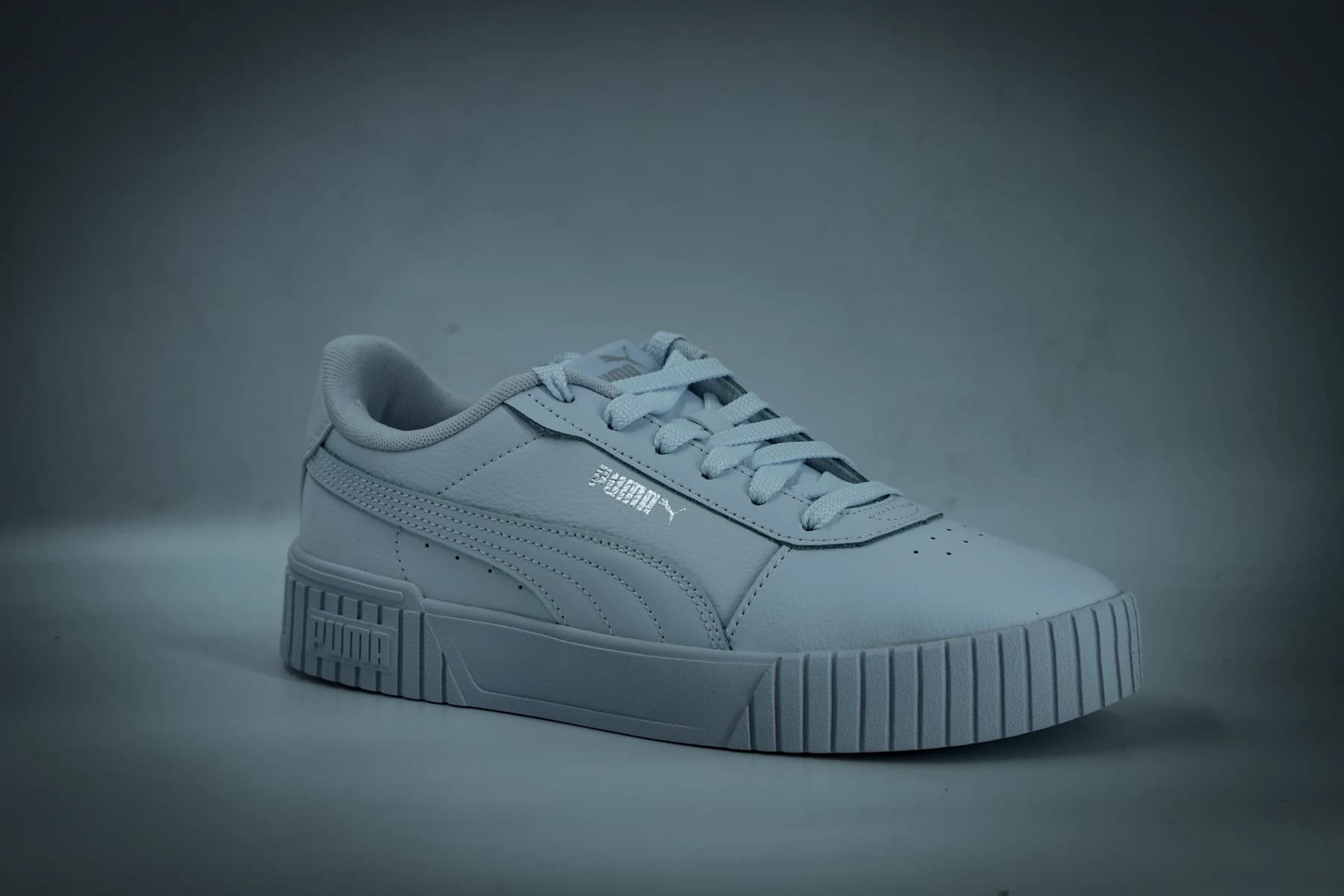 White low-top sneaker photographed in a studio