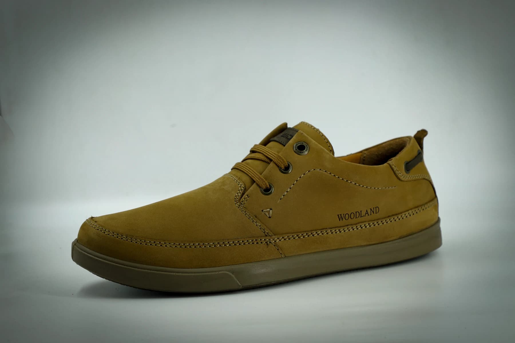 Tan casual shoe photographed against a pale background