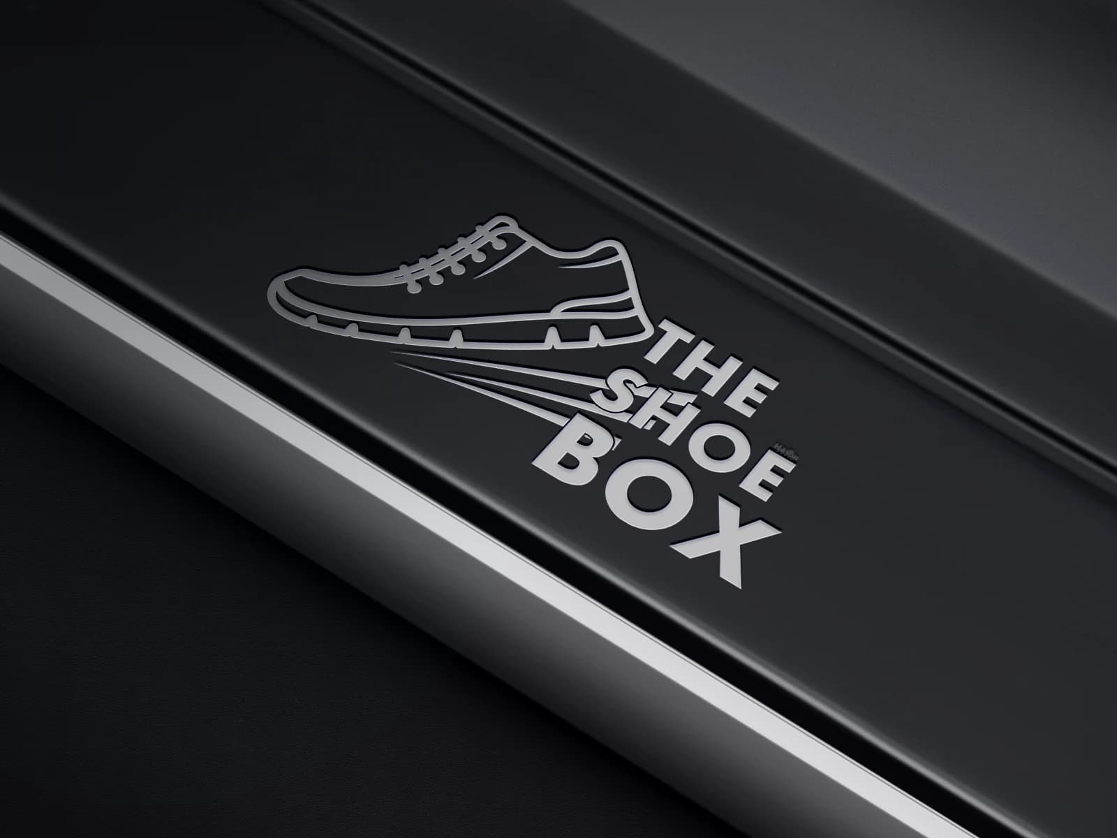 The Shoe Box logo applied to a dark product surface